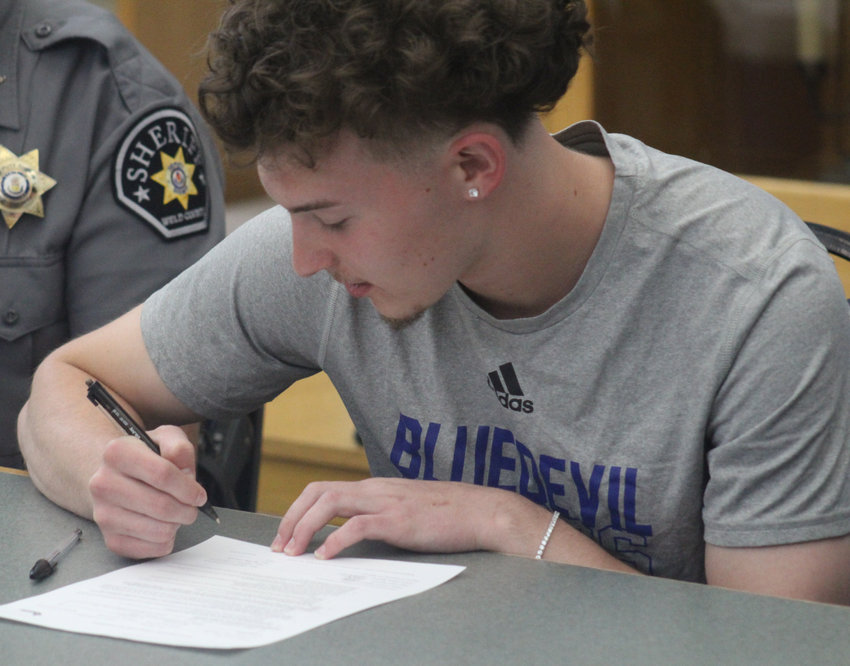 Fort Lupton's Conner Moll puts pen to paper May 26 and signs his letter of intent for college basketball and business studies at Keiser University